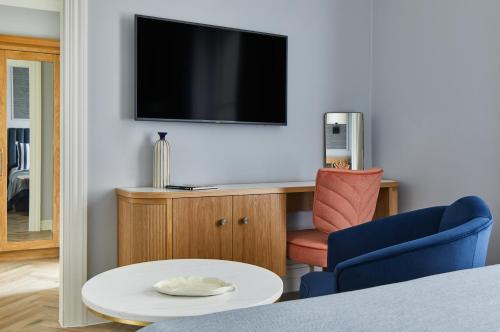 a living room with a tv and a chair and a table at The Grand Brighton in Brighton & Hove