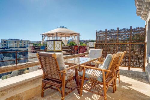 a table and chairs on a balcony with a gazebo at Kasr-ı Kapadokya Cave Suites in Ortahisar