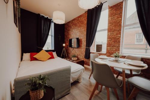 ein Schlafzimmer mit einem Bett und einem Tisch und Stühlen in der Unterkunft Luxury City Apartment-Sleeps 4-Sofa Bed- Free Parking in Nottingham