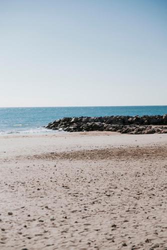 une plage de sable avec l'océan en arrière-plan dans l'établissement La Cabane du Mas Andalou Plage première ligne de mer, à Frontignan