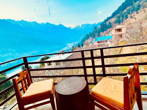a balcony with a table and two chairs and a view at The English Rose, Mussoorie - A Peaceful Hidden Resort By Sitara Group in Mussoorie