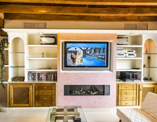 a living room with a tv and a fireplace at La Chirumba in Aldeatejada