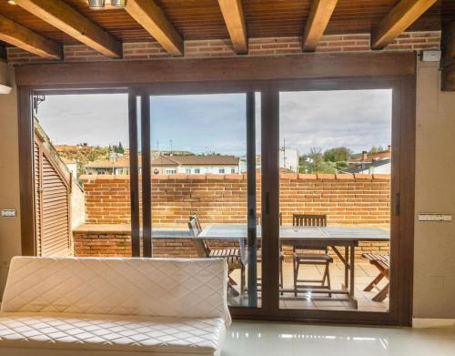 a living room with a large glass door with a table at La Chirumba in Aldeatejada