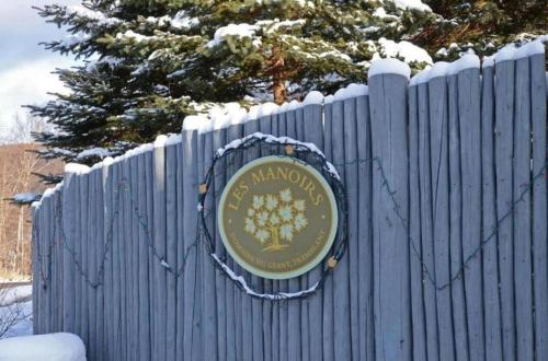 a sign on a blue fence with snow on it at Le Boisé (Les Manoirs) Mont-Tremblant in Mont-Tremblant