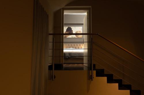 a person sitting on a bed in a stair case at Quentin Prague Hotel in Prague