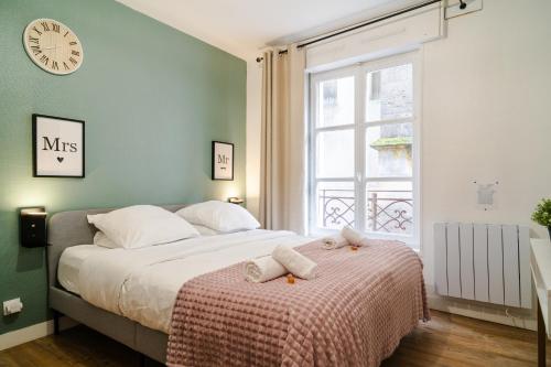 - une chambre dotée d'un lit avec une horloge murale dans l'établissement Le Chevremont, Centre Metz Cathédrale I WIFI I Confort & Cosy, à Metz