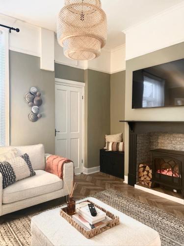 a living room with a couch and a fireplace at Boho Bay Two - Seaside Escape in Cullercoats