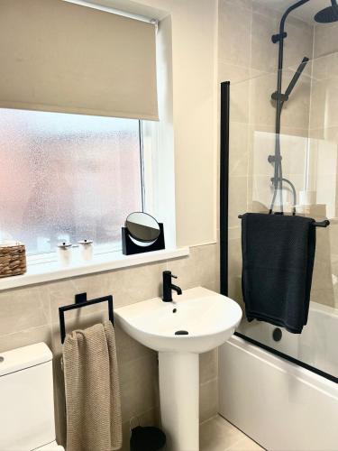 a white bathroom with a sink and a shower at Boho Bay Two - Seaside Escape in Cullercoats