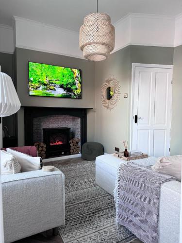 a living room with a tv above a fireplace at Boho Bay Two - Seaside Escape in Cullercoats