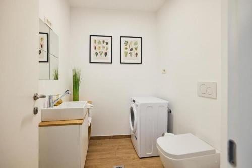 a white bathroom with a toilet and a sink at Vipava River Retreat - Happy Rentals in Vipava