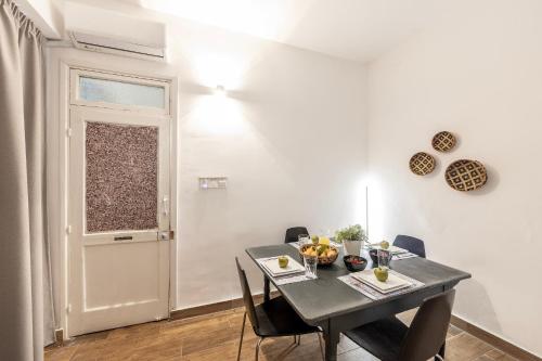 Un comedor con una mesa y sillas y una puerta. en Queen Regina Suites, en Nicosia