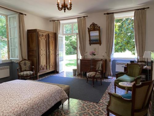 a bedroom with a bed and a table and chairs at LA SEIGNEURIE DE TILLAC in Tillac