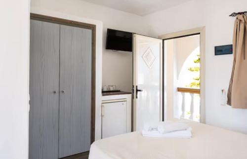 a bedroom with a white bed and a window at Danae Villa in Fira