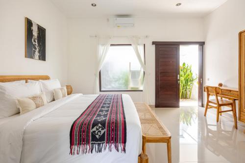 une chambre avec un grand lit et un bureau dans l'établissement Gemstones Villa, à Seminyak