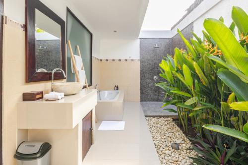 La salle de bains est pourvue d'un lavabo et de plantes. dans l'établissement Gemstones Villa, à Seminyak