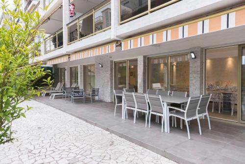 une table et des chaises assises à l'extérieur d'un bâtiment dans l'établissement Jardin d'Azur – Terrace, Calm & Croisette, à Cannes