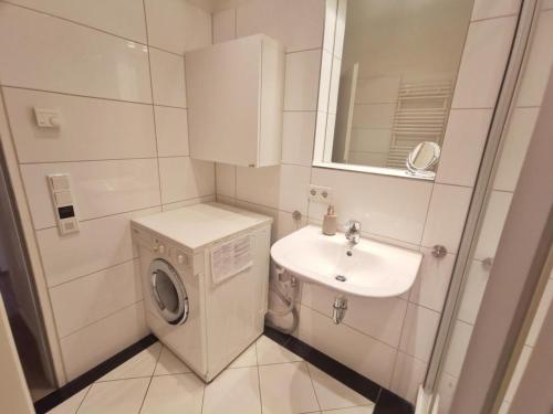 蒂门多弗施特兰德Obj 69 - FeWO Strandläufer 2- bis 4 Personen inkl Strandkorb Top Lage 90 m zum Strand的配有洗衣机和水槽的浴室