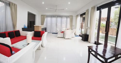 ein Wohnzimmer mit weißen Möbeln und einem Tisch in der Unterkunft Two Bed Room Villa with Pool in Jimbaran