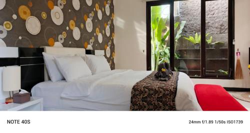 ein Schlafzimmer mit einem weißen Bett und einem Fenster in der Unterkunft Two Bed Room Villa with Pool in Jimbaran