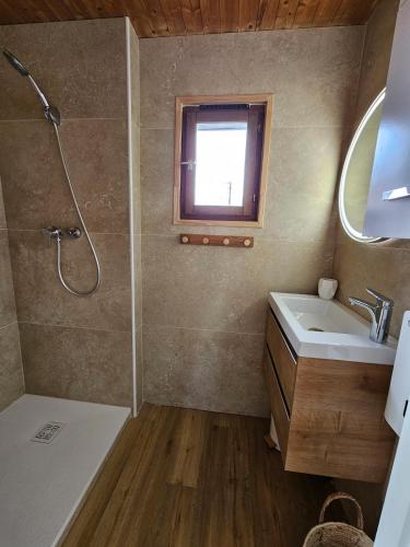 une salle de bain avec une douche et un lavabo et une fenêtre dans l'établissement Chalet Cosy à Bolquère, à Bolquère-Pyrénées 2000