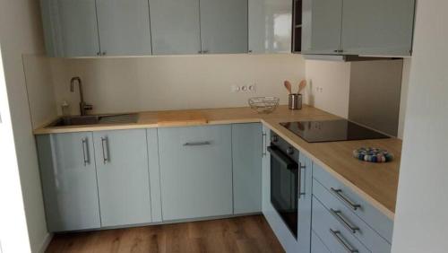 une cuisine avec des armoires blanches et un comptoir en bois dans l'établissement Home in Niort, à Niort