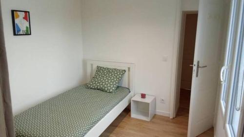 Cette chambre comprend un lit avec un oreiller et une table. dans l'établissement Home in Niort, à Niort