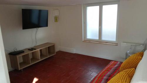 un salon avec une télévision à écran plat au mur dans l'établissement Home in Niort, à Niort