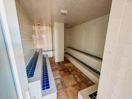 Habitación con azulejos azules en las paredes. en Flamingo - 4 suite -15 gasten - Arraial d' Ajuda, en Porto Seguro