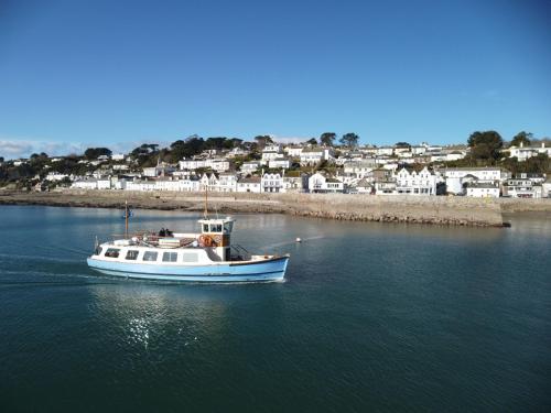 a boat in the water with a town in the background at Chupra in Saint Mawes