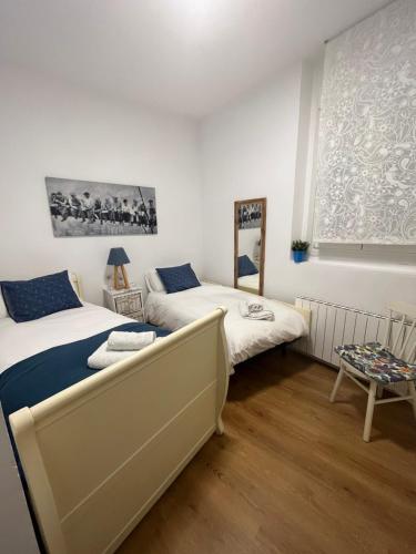 une chambre avec deux lits et une fenêtre dans l'établissement El Botxito, à Bilbao