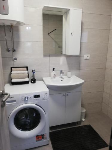 a bathroom with a washing machine and a sink at Kuća za podmor Olea in Nečujam