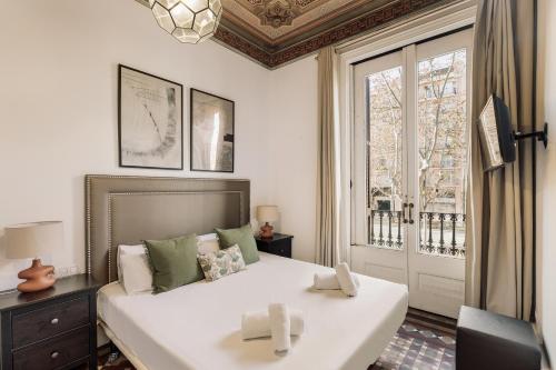 a bedroom with a large white bed and a window at Ola Living Arc de Triomf in Barcelona