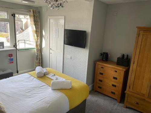a bedroom with a bed and a tv on the wall at The Wildings Hotel & Tudno's Restaurant in Llandudno