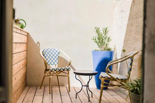 a patio with two chairs and a table and a blue vase at Le Petit Avignon - chambres & appartement à deux pas du Pont d'Avignon et du Palais des Papes in Avignon