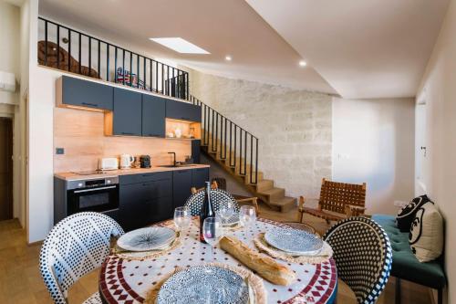 a kitchen and dining room with a table and chairs at Le Petit Avignon - chambres & appartement à deux pas du Pont d'Avignon et du Palais des Papes in Avignon