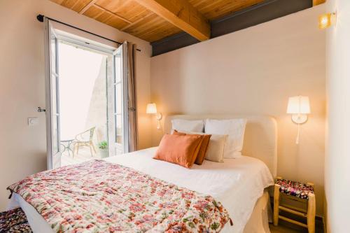 a bedroom with a bed and a large window at Le Petit Avignon - chambres & appartement à deux pas du Pont d'Avignon et du Palais des Papes in Avignon