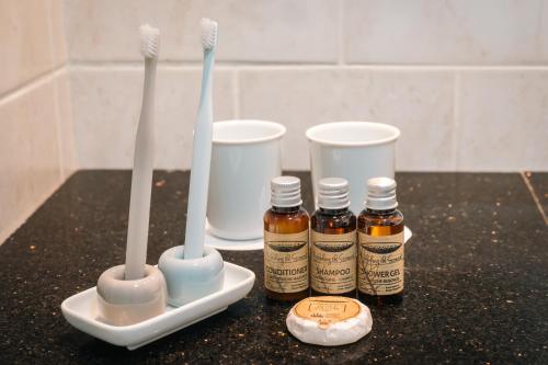 a counter with three toothbrushes and two bottles of honey at Beresford Hotel in Dublin