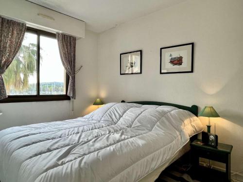 une chambre avec un grand lit blanc et une fenêtre dans l'établissement Appartement 2 pièces cabine 6 couchages ARGELES SUR MER AR660-022, à Argelès-sur-Mer