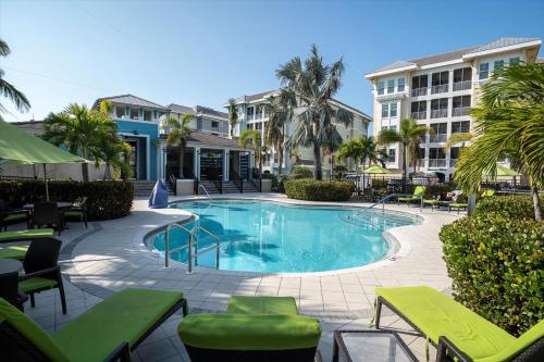 a swimming pool with tables and chairs in a resort at Latitude Adjustment Penthouse by Coastal Chic in Bradenton