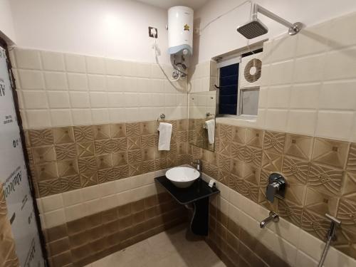 a small bathroom with a sink and a mirror at Swet Palash Resort in Purulia