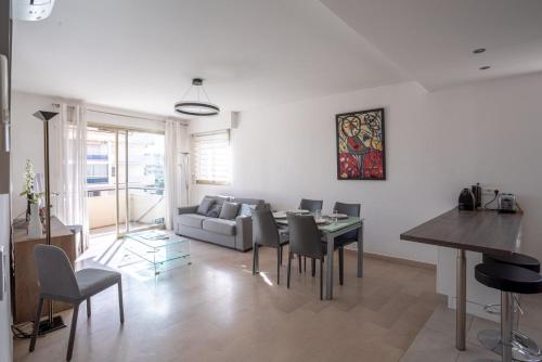 un salon avec un canapé, une table et des chaises dans l'établissement Côté Scène – Terrace & Near Croisette, à Cannes