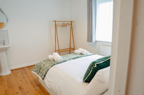 a bedroom with a bed with white sheets and a window at Modern 2 bed Bromley House in Grove Park