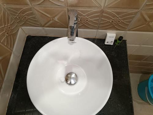 a white toilet in a bathroom with a sink at Swet Palash Resort in Purulia