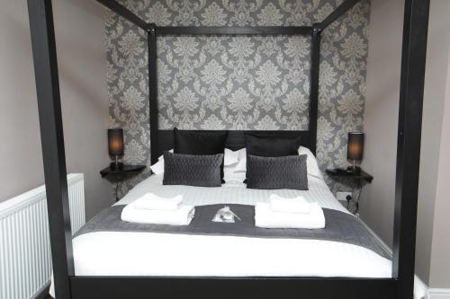 a bedroom with a black and white bed with two lamps at OYO Glyn Valley Hotel in Glyn-Ceiriog