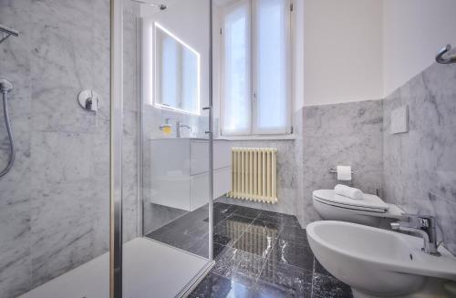 a bathroom with a shower and a toilet and a sink at Apt In Villa Bianca in Lierna