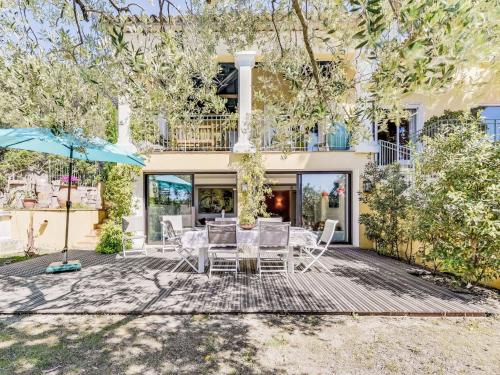 une terrasse avec des chaises et un parasol en face d'une maison dans l'établissement Apartment Villa La Romane by Interhome, à Saint-Tropez