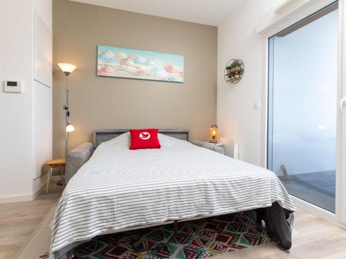 une chambre avec un lit avec un oreiller rouge dessus dans l'établissement Studio Résidence de l'Hermine by Interhome, à Saint-Malo