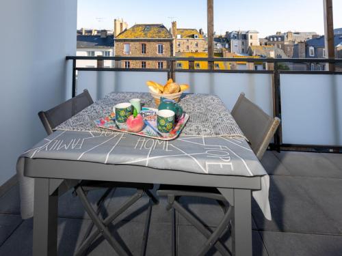 - une table avec un plateau de nourriture sur le balcon dans l'établissement Studio Résidence de l'Hermine by Interhome, à Saint-Malo