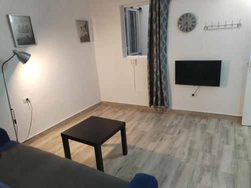 ein Wohnzimmer mit einem Tisch und einem TV an der Wand in der Unterkunft Vista Puerto Studio 1 Pers No balcon in Arguineguín