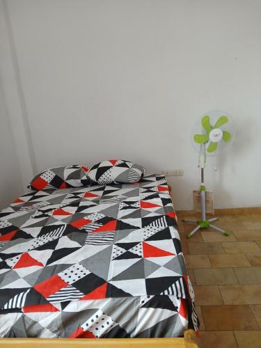 a bed with a colorful quilt on it in a room at Perezoso inn in Iquitos